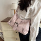 Pink soft vegan leather hobo bag with front buckle strap worn over the shoulder with a white blouse