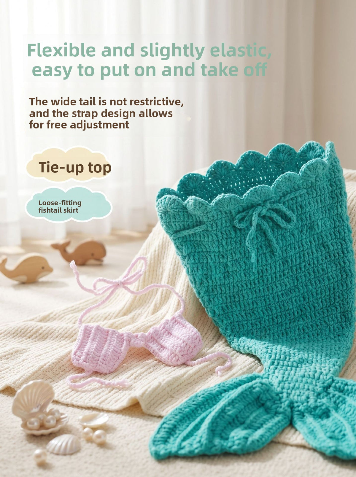 Teal crochet mermaid tail with drawstring waist and pink tie back top on a cream knit throw