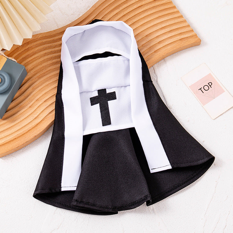 Black and white pet nun costume laid flat on a wooden tray, hood and cross front panel visible
