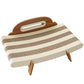 Cat scratcher lounger on a white background showing cream and brown corrugated stripes, headboard and two legs