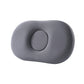 Dark gray oval memory foam pillow with round center pad set into the middle on white