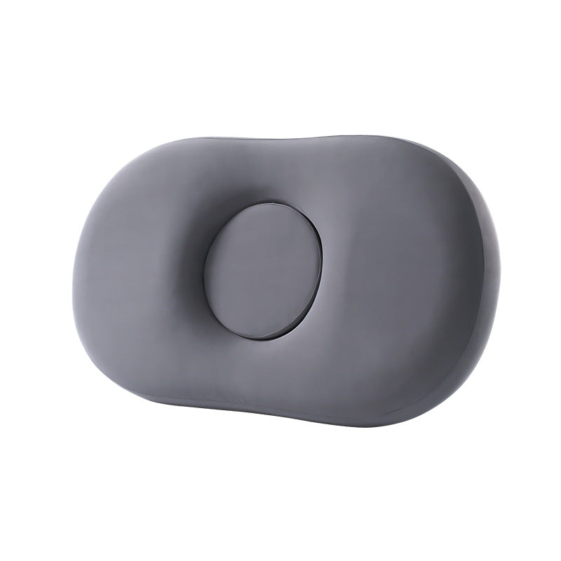 Dark gray oval memory foam pillow with round center pad set into the middle on white