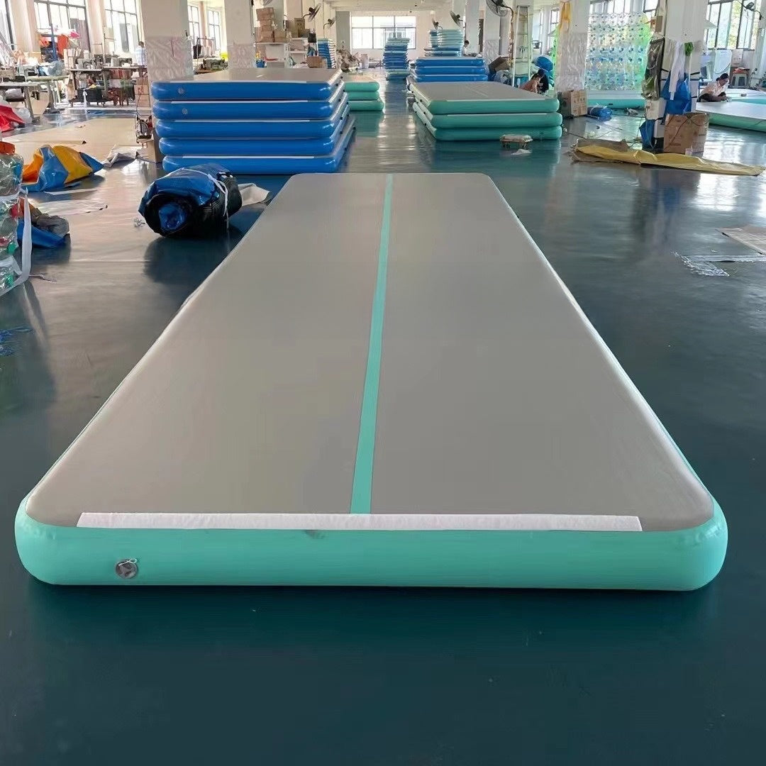 Mint green inflatable air track mat laid flat with a gray top, a center stripe and a round side valve