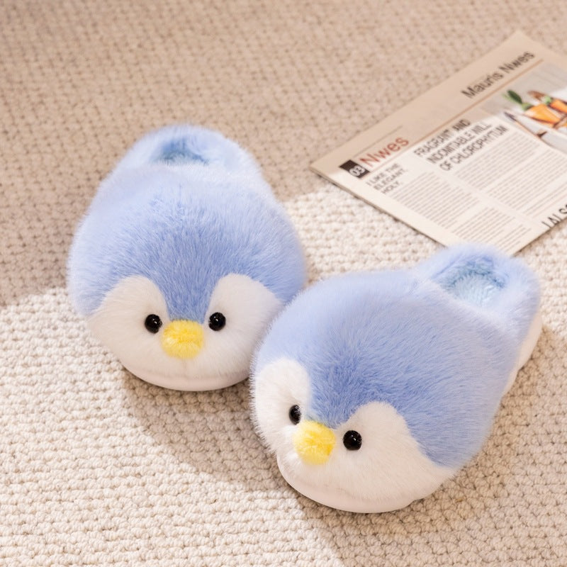 Pair of blue plush penguin slippers with yellow beaks and black eyes on a beige rug beside a newspaper, Blue Open-Heel