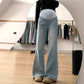 Light blue flared maternity jeans with a gray stretch belly panel, front view in a bright room