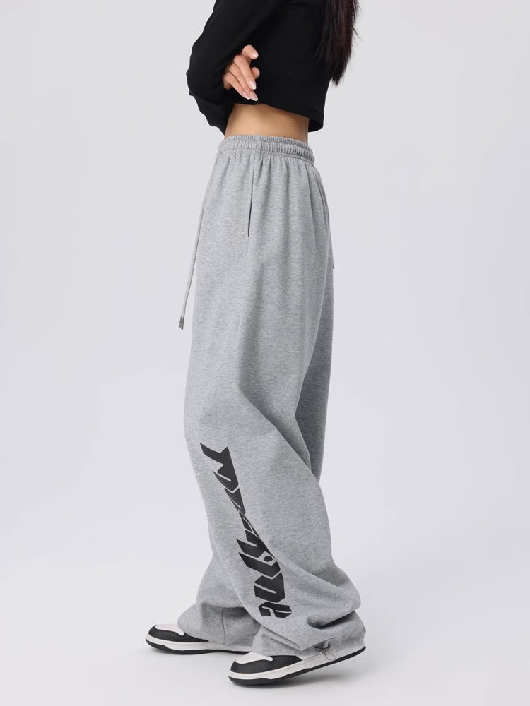 Side view of loose wide leg dance pants showing the streetwear graphic down one leg