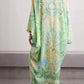 Back view of the light green botanical print dress with wide sleeves and a long flowing skirt