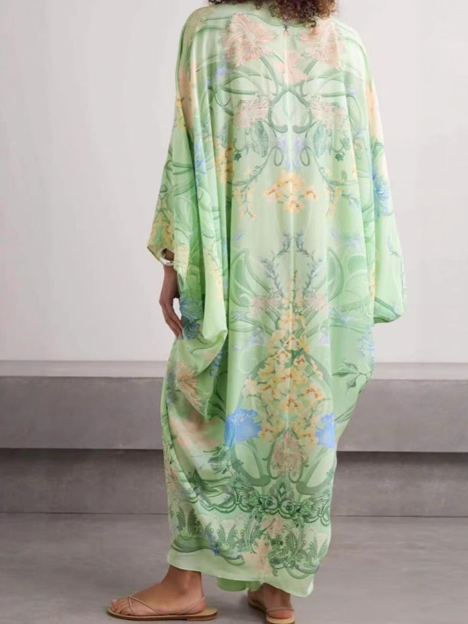 Back view of the light green botanical print dress with wide sleeves and a long flowing skirt