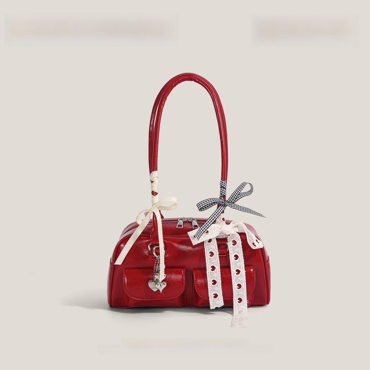 Patent shoulder bag shown beside a phone and small wallet as everyday carry reference