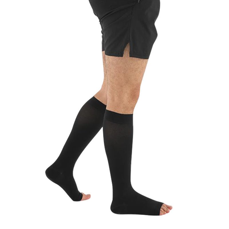 Black mid calf compression sleeve on the leg with a printed size measurement table