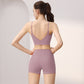 Back view of a woman in a dusty rose V-back sports bra and high-waist shorts set, size L option
