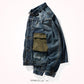 Side angle of dark blue denim jacket with olive canvas pocket and buttoned cuff