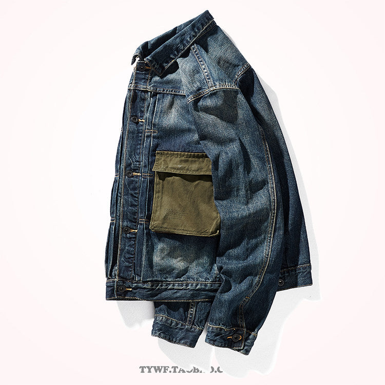 Side angle of dark blue denim jacket with olive canvas pocket and buttoned cuff