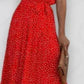 Red polka dot halter neck sleeveless tiered swing maxi dress worn by a model