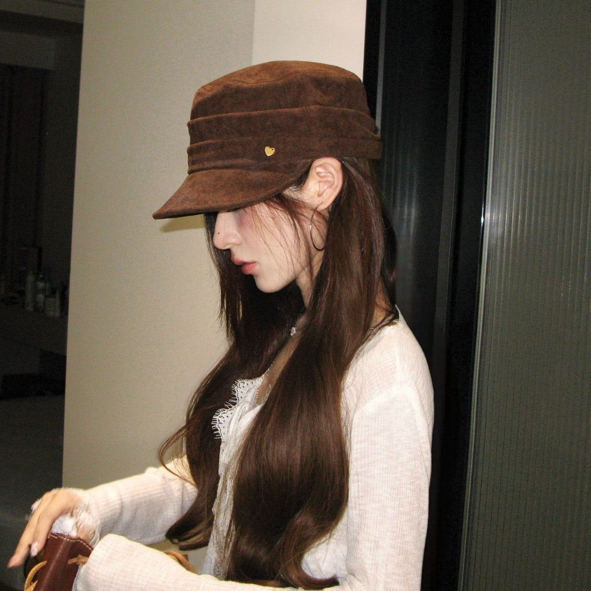 Woman wearing a brown vegan suede flat top cap with a short curved peak
