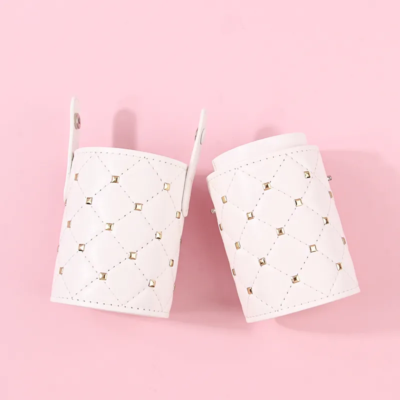 Studded white PU leather brush holder standing upright, gold studs catching light on the quilted body
