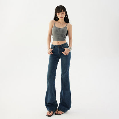 Womens low rise flared dark wash denim jeans on a model, full length front view with flat sandals