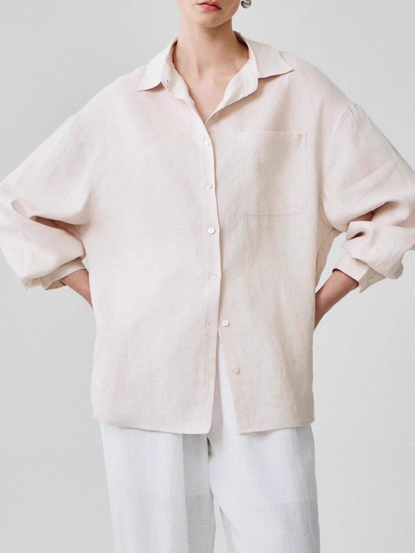 Black relaxed linen shirt worn open over a fitted dress as a light layer