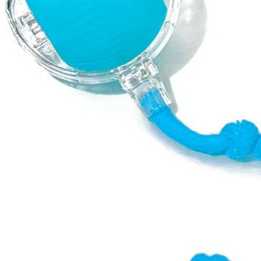 Pink self rolling pet ball with glowing light and rope tail during indoor chase play