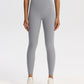 High-waisted stretch yoga leggings for women paired with white sneakers in studio