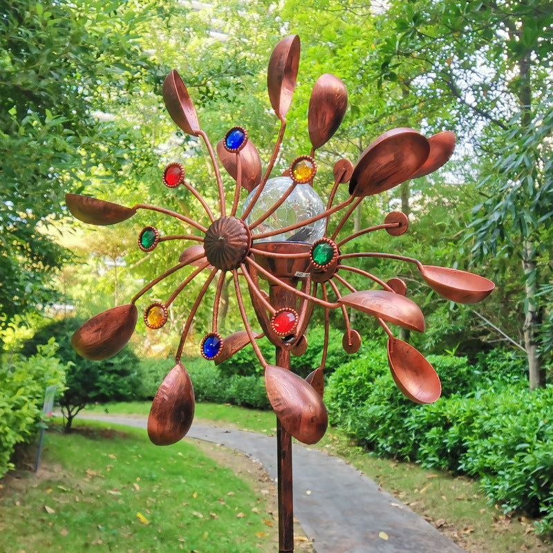 Solar wind spinner stake spinning in the breeze at dusk in the garden