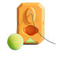 Top view of the orange rectangular rebound base with a green triangle tab, nylon rope and a tennis ball beside it