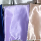 Violet glossy silk pillowcase beside a champagne one and a navy one
