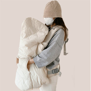 Back view of the quilted baby carrier cape with the fold up hood raised
