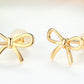 18K Gold Bow Earrings for Women | scale reference next to a hand