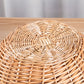Close up of the woven rattan centre on the lid of a round wicker basket showing the handwoven pattern