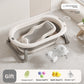 Baby bathtub with mesh bath rack and a printed floating bath mat beside it on a tiled floor