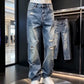 Blue distressed denim jeans with belt loops and a zip fly on a mannequin with white sneakers