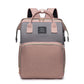 Pink and gray diaper backpack front view with two top handles, a small woven label and a pink front pocket