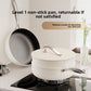 White non-stick wok with lid and steamer tier on a gas hob beside a coated frying pan seen from above