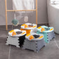 Four folding travel potties in orange, gray, blue and white grouped on a bathroom floor