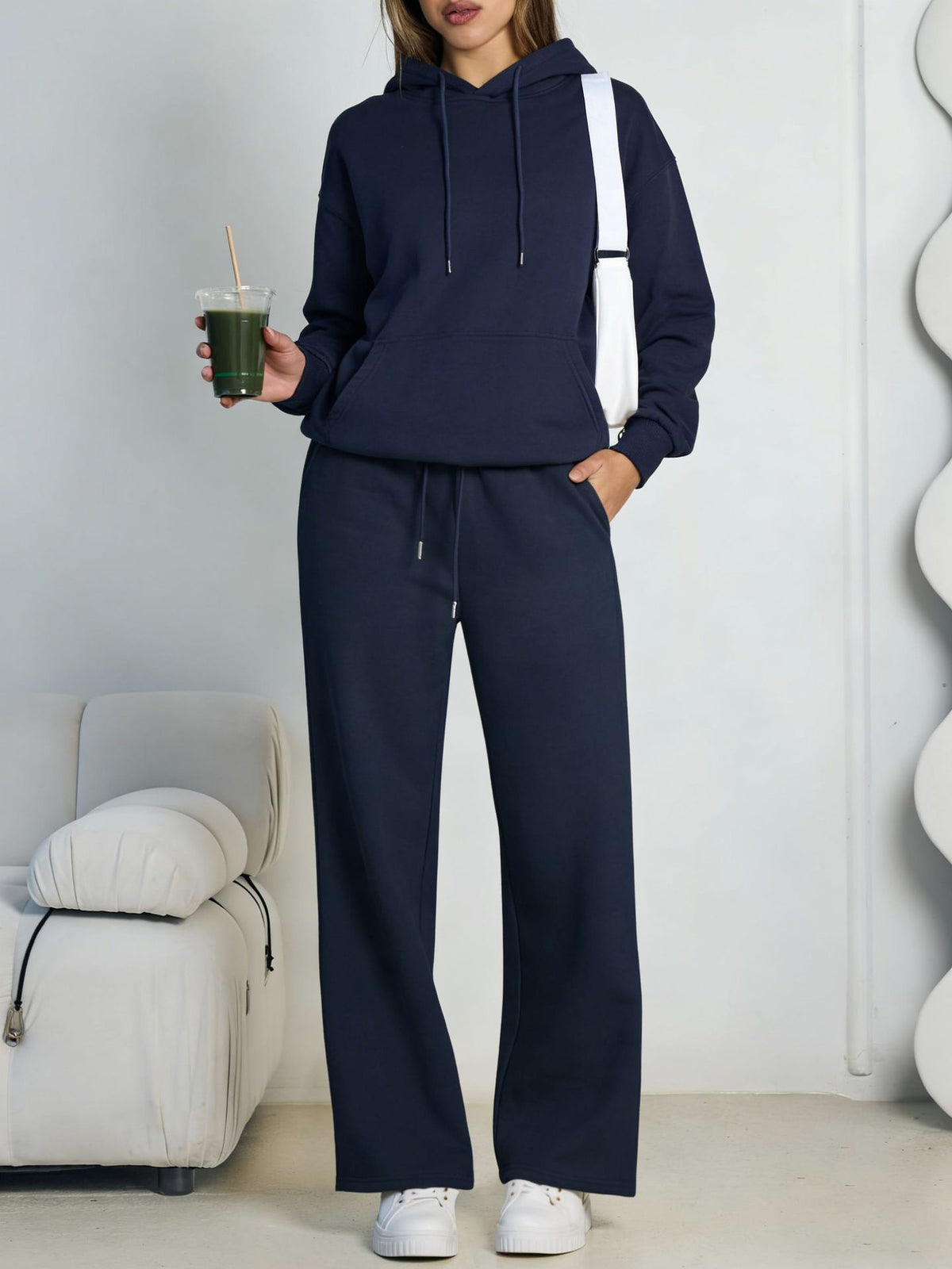 Navy blue fleece hooded sweatshirt and wide-leg sweatpants set worn by a model