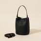 Leather bucket bag styled in a modern interior next to everyday items