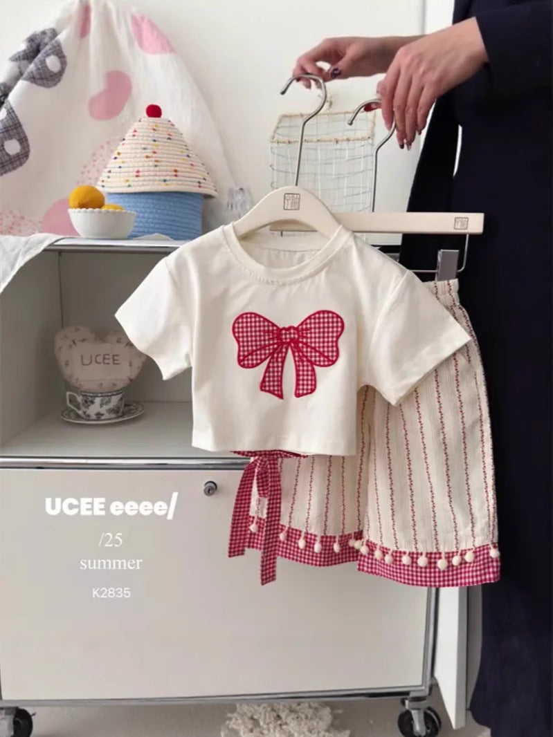 Girls' bow print short sleeve set styled as a casual warm-weather outfit