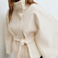Short cape jacket with cape cut sleeves and a matching self tie belt at the waist