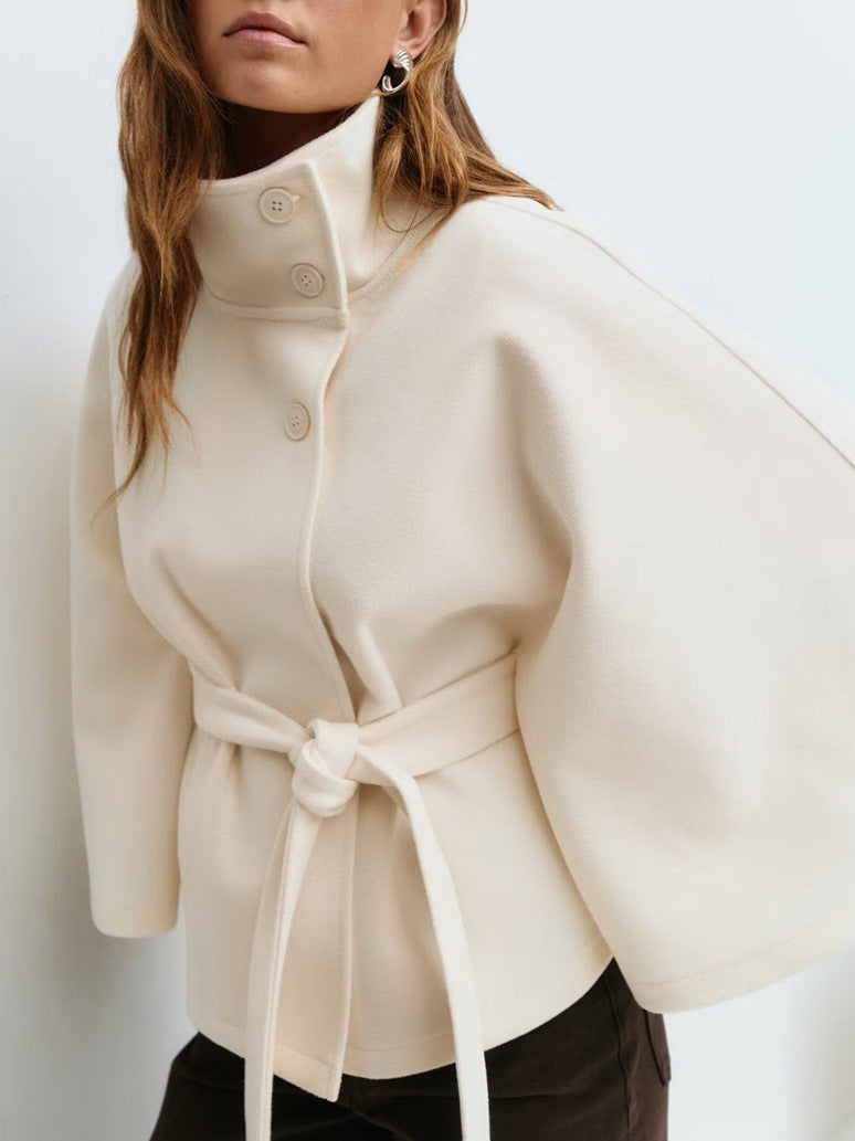 Short cape jacket with cape cut sleeves and a matching self tie belt at the waist