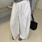 White cotton trousers showing shirred elastic drawstring waist and wide leg