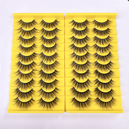 Thick fluffy cat eye false strip eyelashes in black on a yellow ten pair tray, two yellow trays side by side