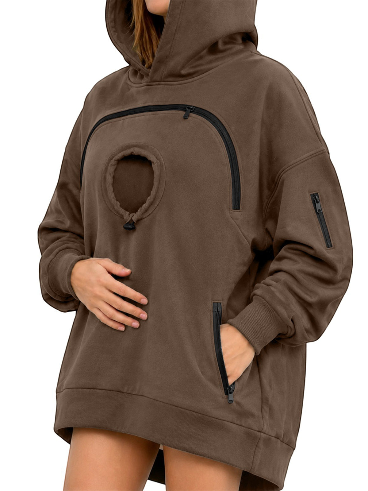 Brown oversized fleece hoodie with a round chest pocket, arched zipper and zipped hand pockets on a woman