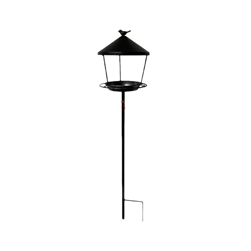 Cedar bird feeder hanging from a maple branch in a backyard