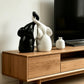 Black and white elephant figurine pair with entwined trunks on a wooden TV console