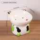 Green cow design ceramic raised pet bowl with green ears and feet, 15 by 14 cm and 13 cm high
