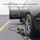 Car with an open door and a tire inflator on the ground, its power cord reaching a rear wheel