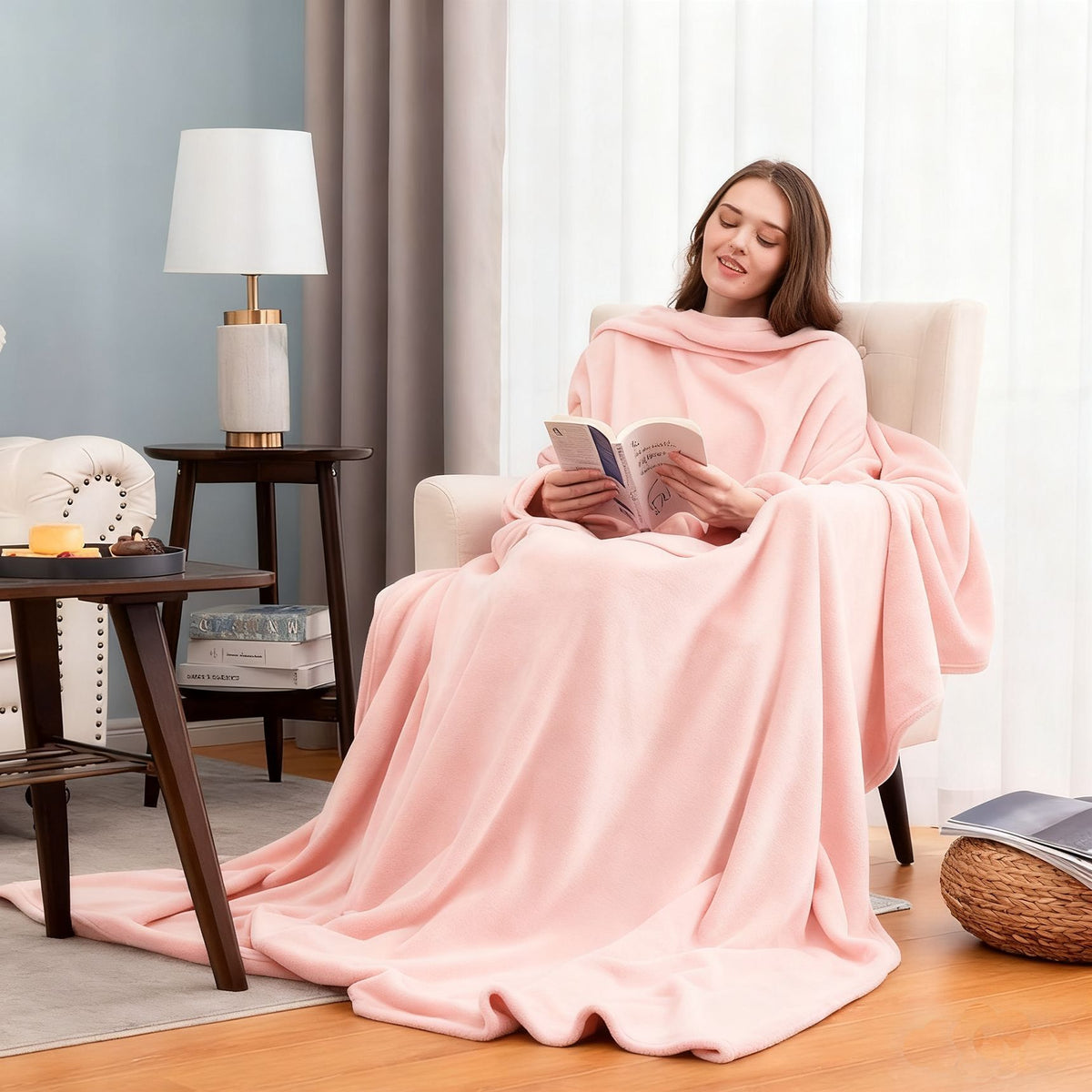 Woman reading in an armchair in a pink plain flannel sleeved blanket draped over her lap, Flannel pink option
