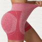 Red heather yoga shorts with the wide waistband stretched out to show the knit give