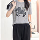 Glacier Gray short sleeve silk blouse with zebra motif styled with black trousers